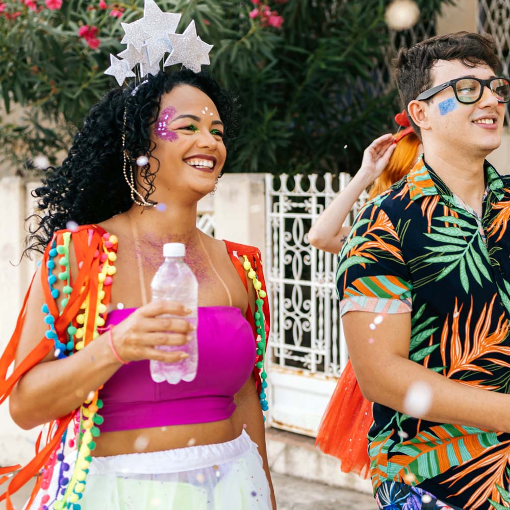 Na imagem, foliões aproveitam o bloquinho de carnaval enquanto se mantêm hidratados
