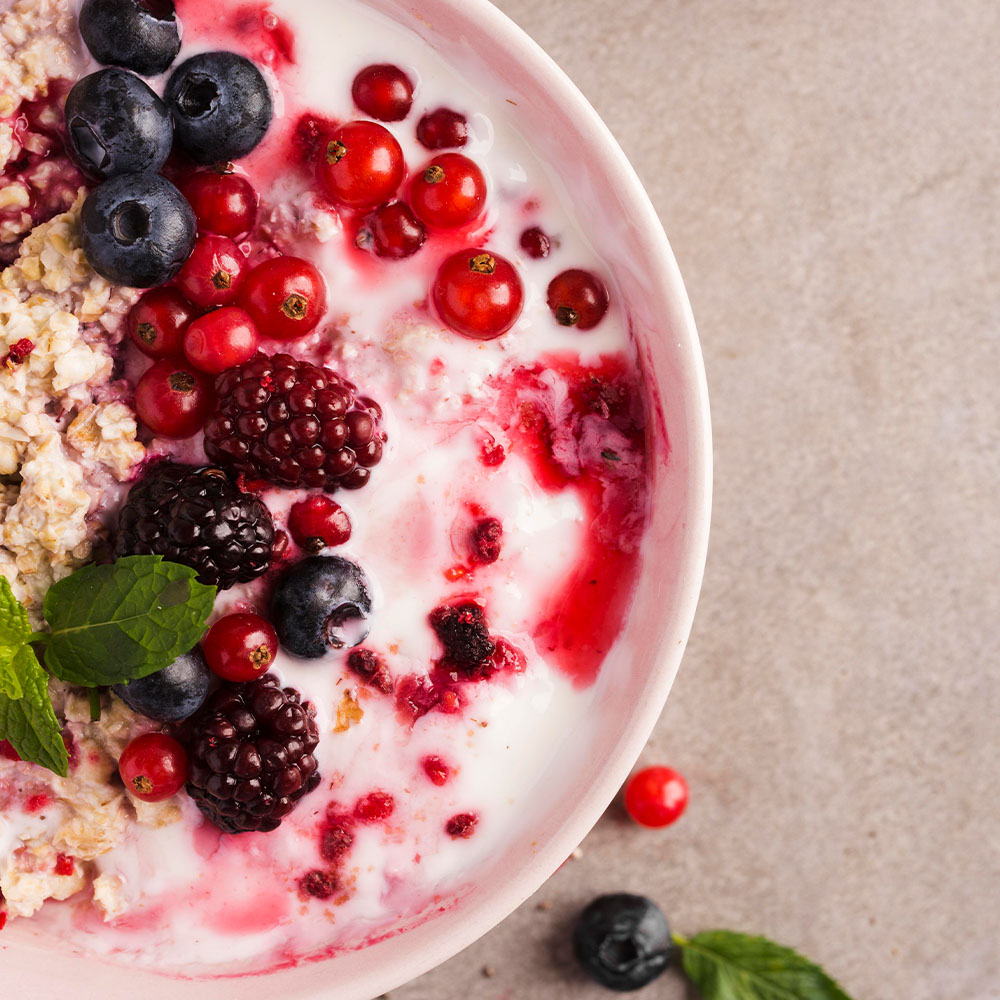 Na foto, um bowl de iogurte com frutas vermelhas.